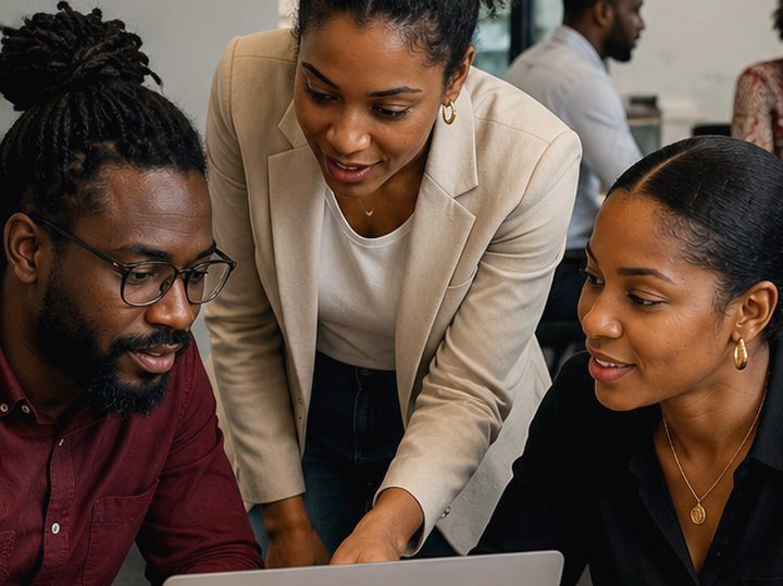 Une formatrice AUMA accompagne un collaborateur devant un écran, en situation de travail.